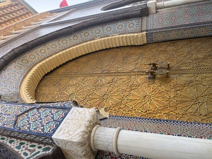 Une vue rapprochée d'une porte dorée au design orné.