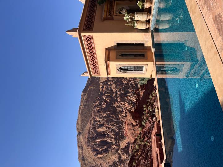 Bâtiment moderne avec une vue panoramique sur les montagnes de roches rouges et une piscine.