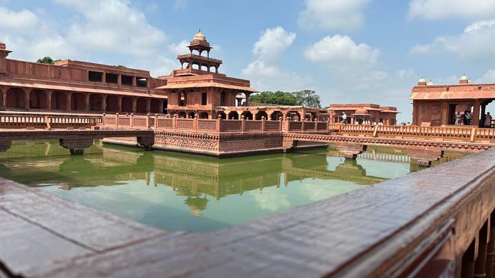 Structure historique en grès avec bassin réfléchissant.