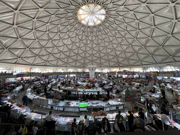 Intérieur d'un marché sous un grand plafond voûté.