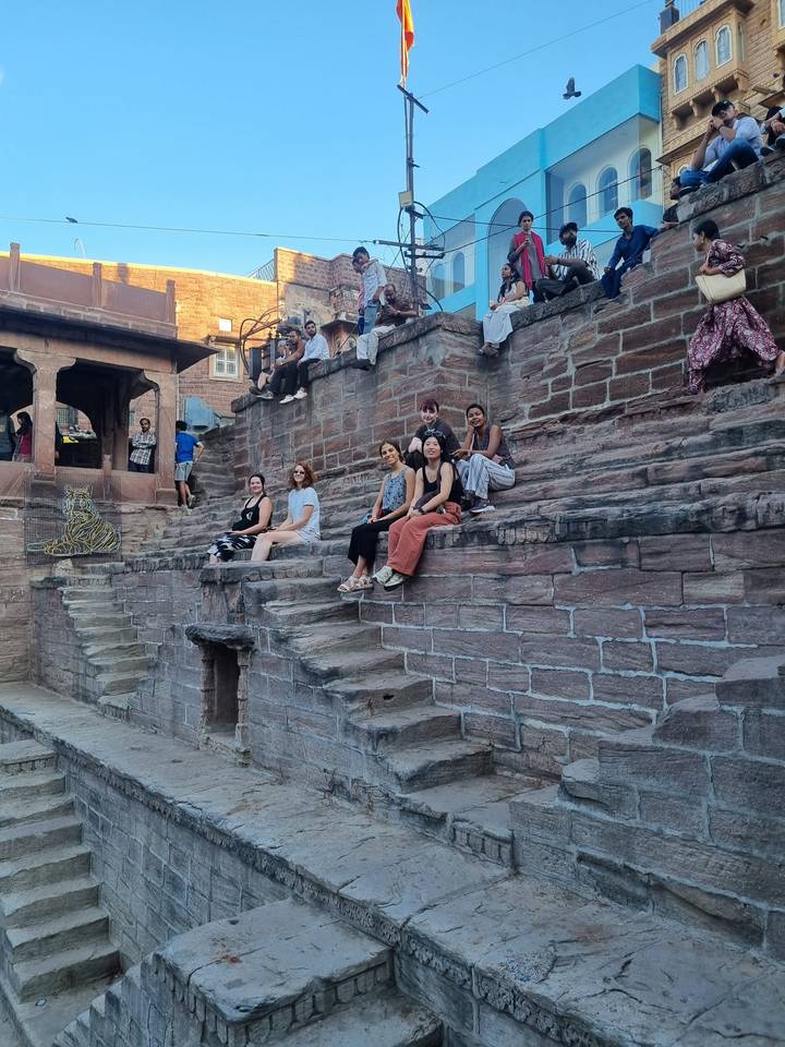 Un groupe de personnes assises sur d'anciens escaliers en pierre.