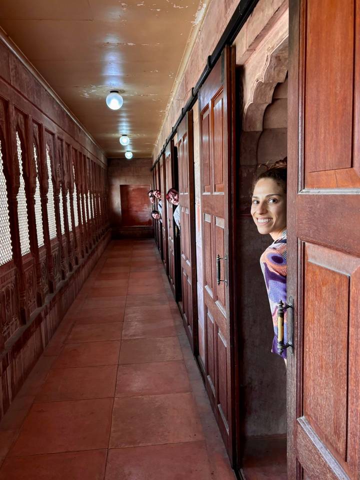 Des personnes qui regardent furtivement depuis derrière des portes dans un couloir.