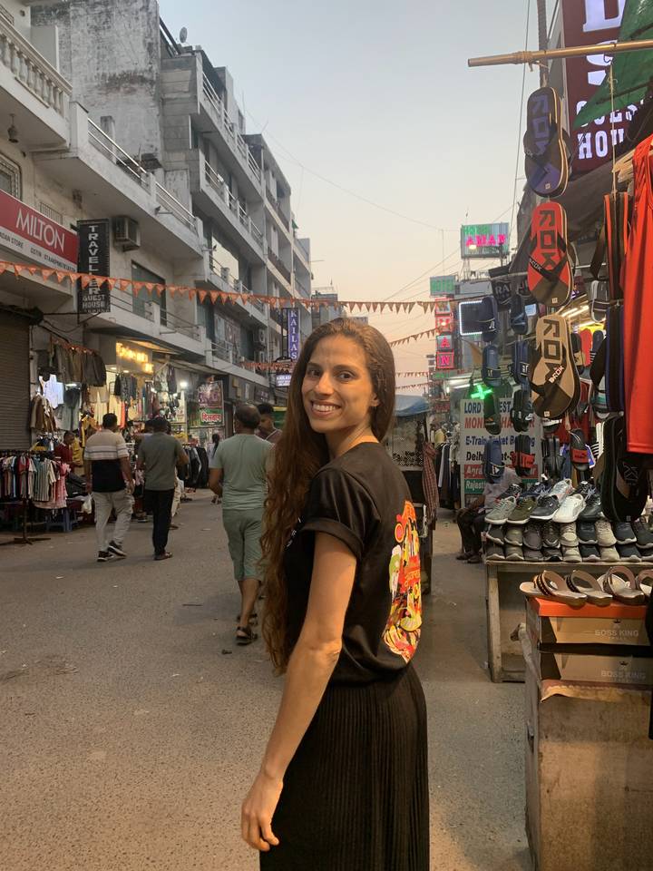 Une femme debout dans une rue de marché animée.