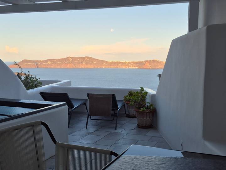 Patio de style méditerranéen avec chaises longues donnant sur la mer.