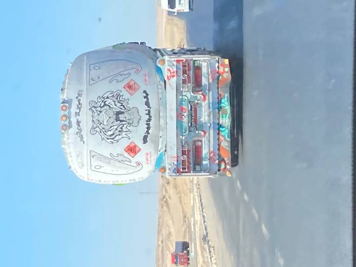 Camion décoré sur une autoroute dans un paysage désertique.