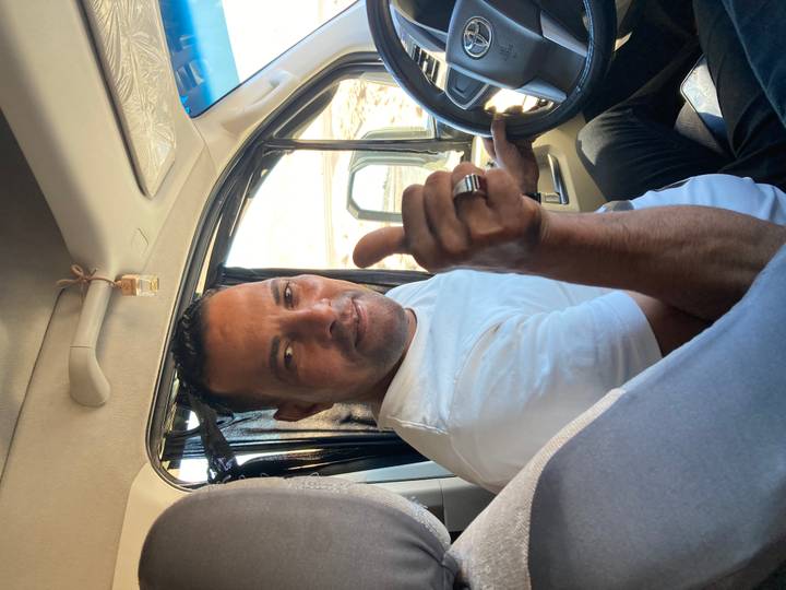 Homme à l'intérieur d'un véhicule faisant un geste de pouce levé.
