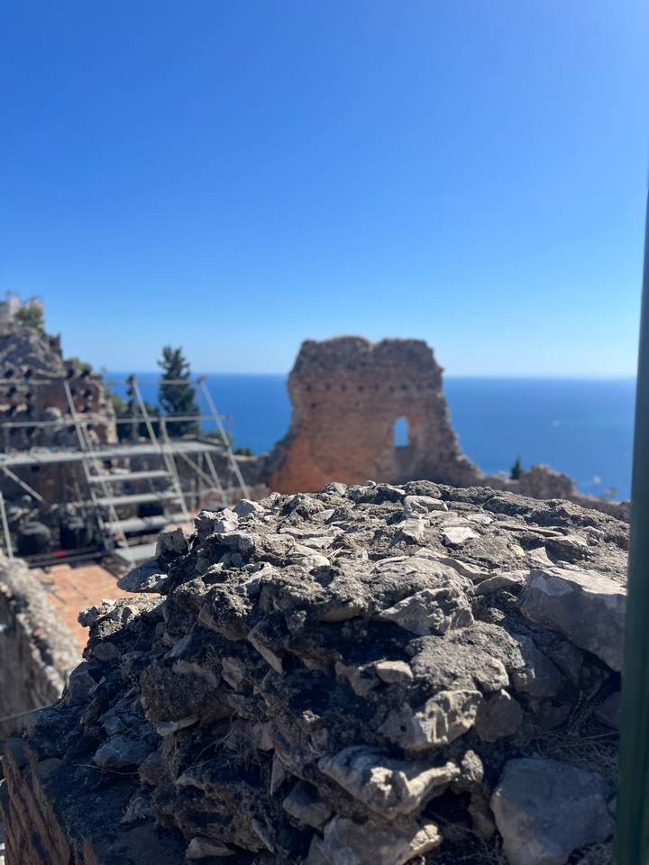 Vue floue de ruines antiques avec la mer bleue en arrière-plan.