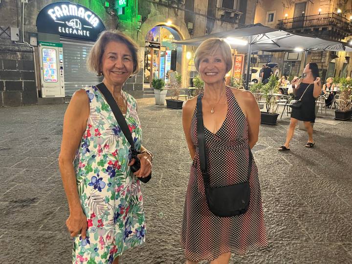 Deux femmes posant dans un marché nocturne.