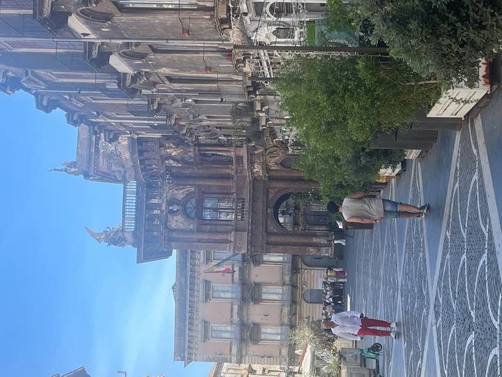 Homme marchant devant la façade d'un bâtiment historique.