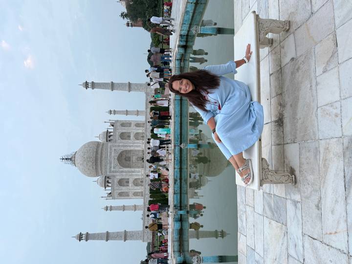 Femme posant avec le Taj Mahal en arrière-plan.