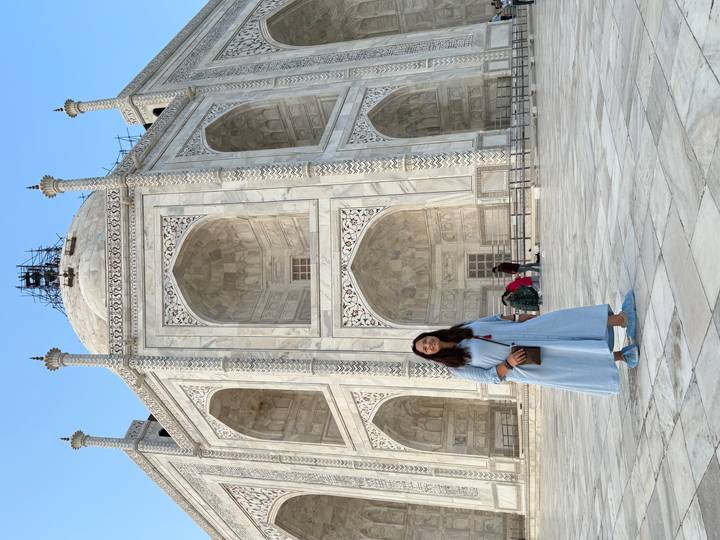Femme devant le Taj Mahal avec une vue en angle.