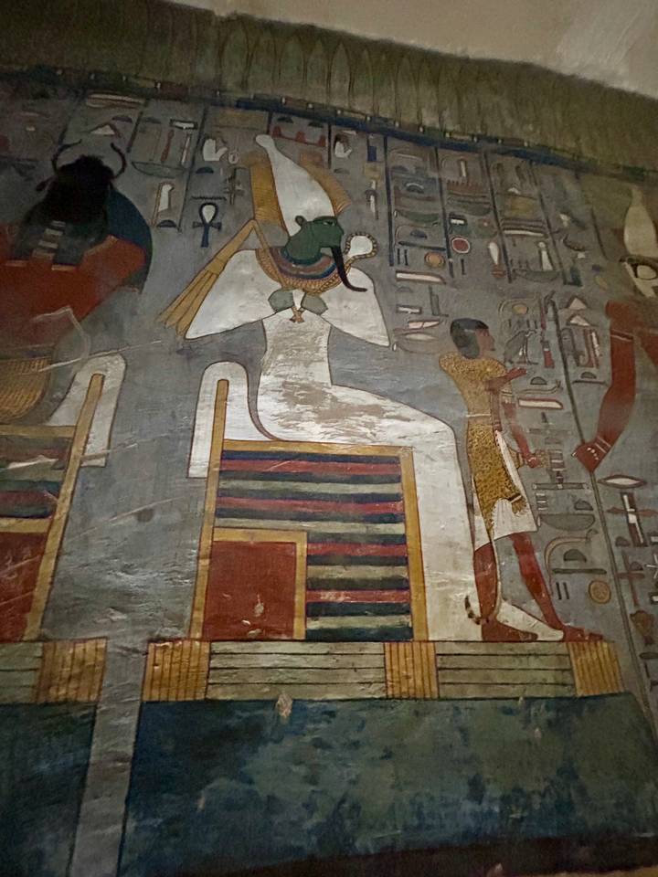 Peinture murale égyptienne antique colorée représentant une figure assise.