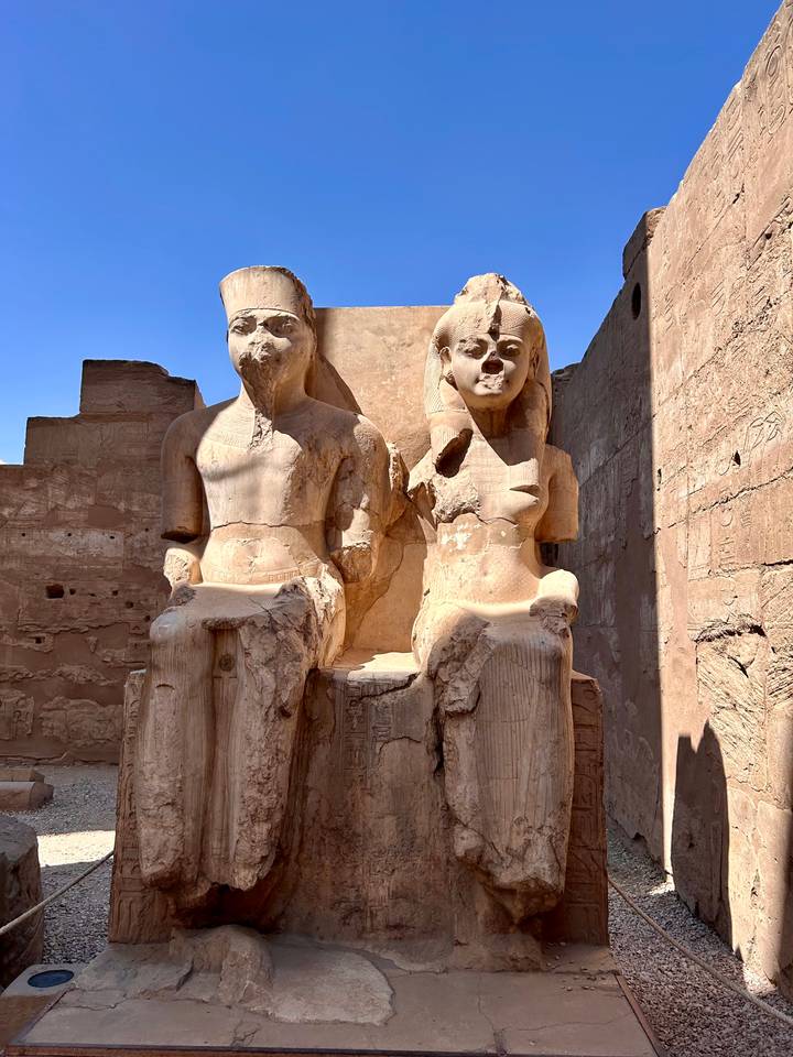 Grandes statues de pharaons dans un temple antique.