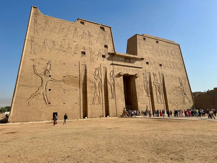 Façade d'un temple égyptien antique avec des hiéroglyphes et des gens.