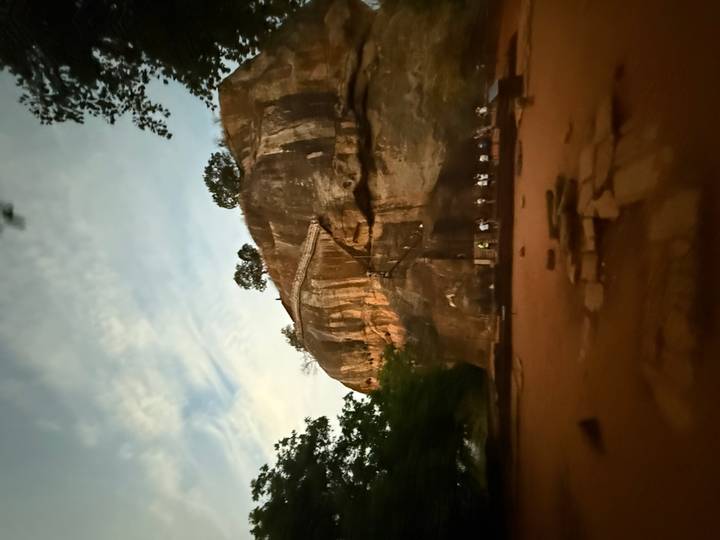 Forteresse rocheuse avec des gens montant les escaliers au crépuscule.