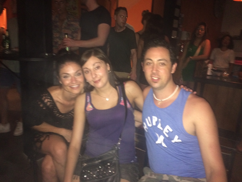 Blurred photo of three people in low-light conditions.