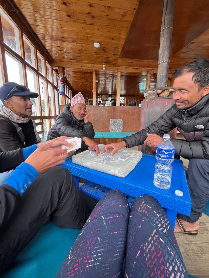 Group of people playing cards in a cozy indoor setting.