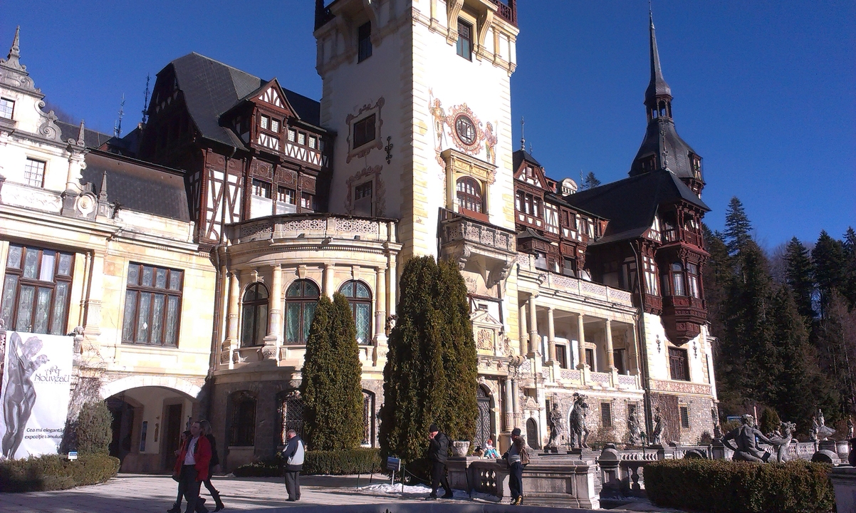 Grand château historique avec une tour d'horloge et des motifs complexes.