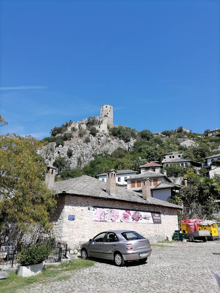 Colina fortificada con edificios históricos y cielo azul.