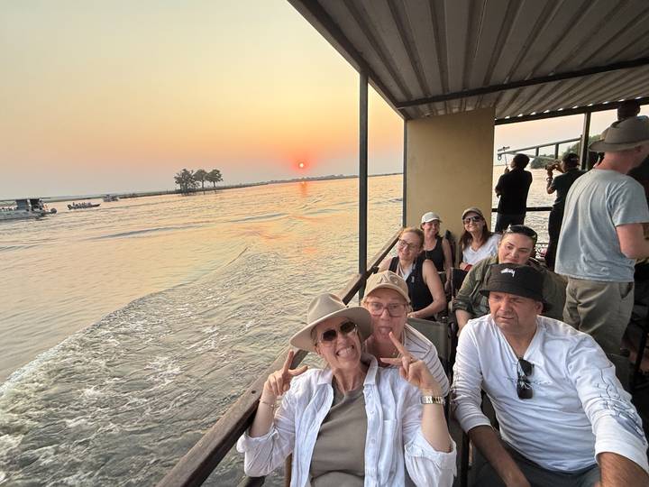 Des passagers sur un bateau profitant d'un coucher de soleil.