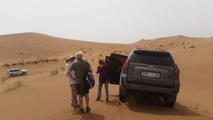 Touristes avec véhicules dans un paysage désertique.