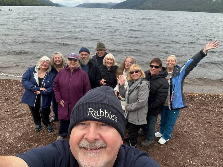 Groupe de personnes souriant au bord d'un lac.