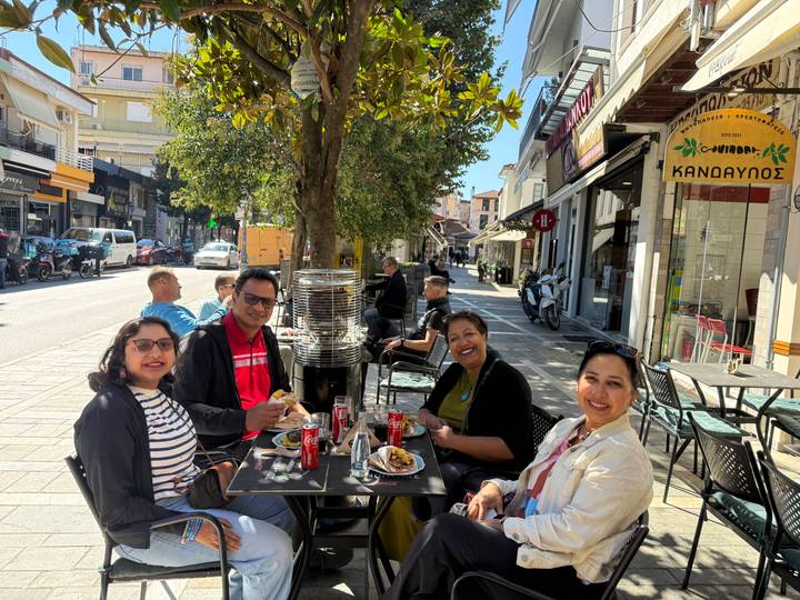 Groupe de personnes dînant dans un café en plein air.