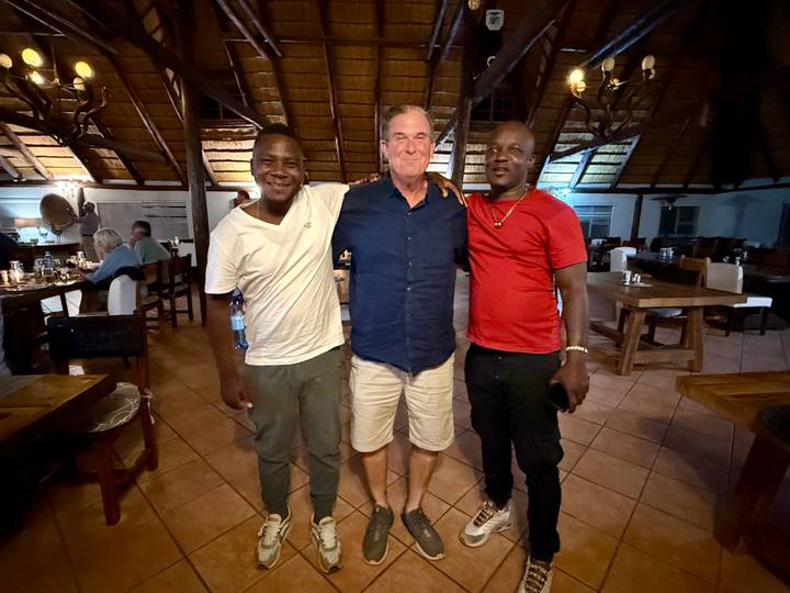 Trois personnes posant à l'intérieur d'un restaurant rustique.
