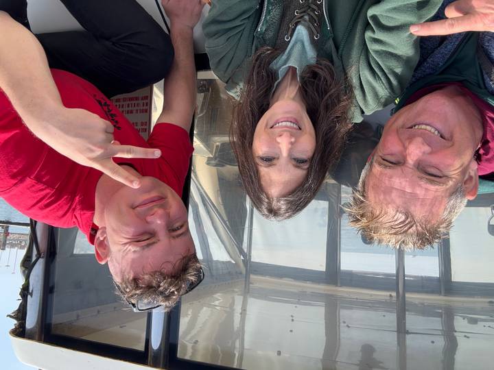 Trois personnes prenant un selfie sur un bateau.