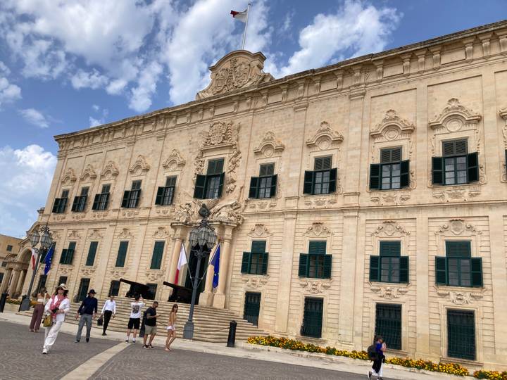 Bâtiment historique dans une ville européenne avec des gens qui marchent.
