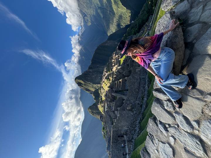 Personne assise avec les ruines du Machu Picchu en arrière-plan.