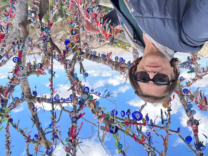 Personne debout devant un arbre décoré avec des amulettes de mauvais œil.