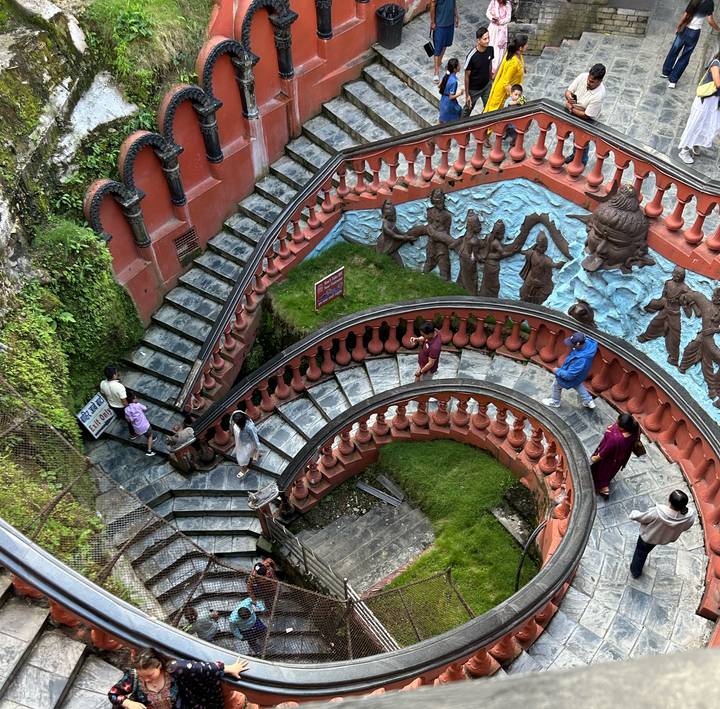 Un escalier en colimaçon avec des sculptures artistiques sur les murs.