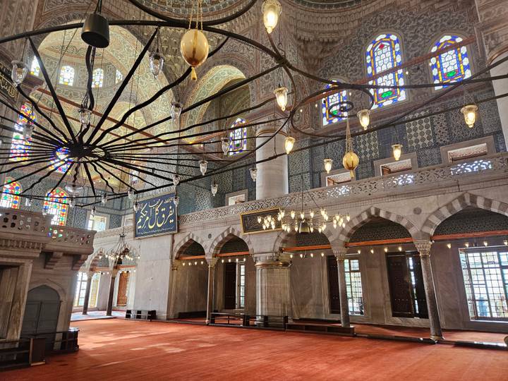 Intérieur d'une mosquée ornée avec des vitraux.