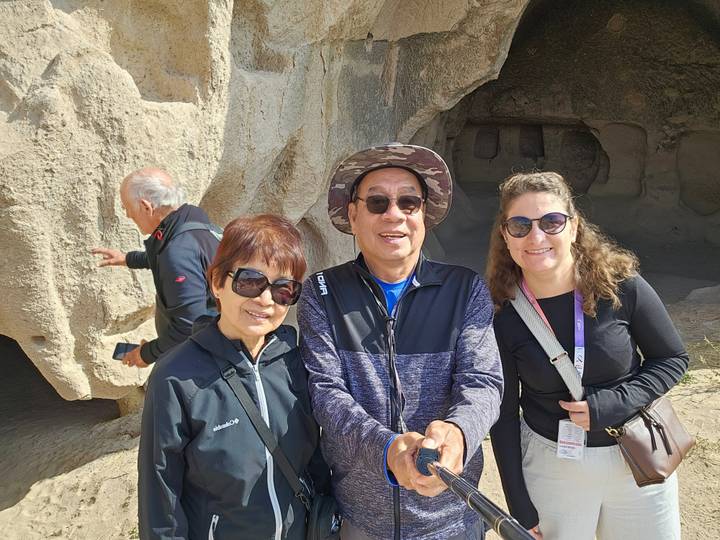 Touristes prenant la pose devant des structures ressemblant à des grottes.