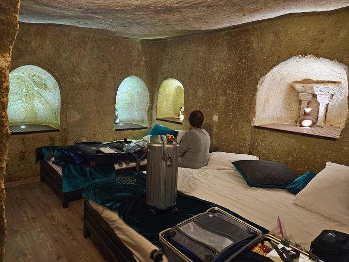 Intérieur d'une chambre dans une grotte avec une valise sur le lit.