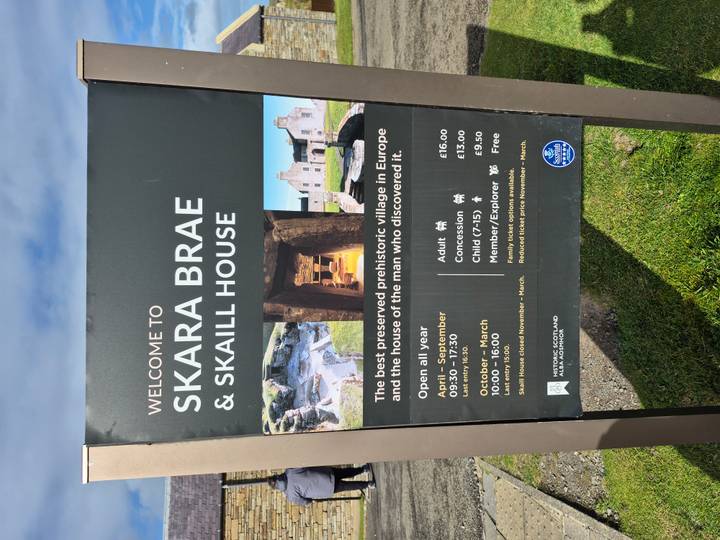Panneau d'information avec les horaires d'entrée et les prix à Skara Brae.