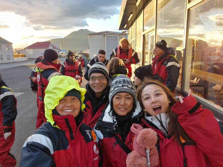 Groupe de personnes en équipement d'hiver posant avec un paysage montagneux en arrière-plan