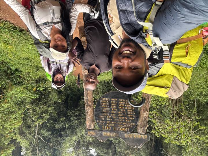 Groupe de randonneurs posant devant un panneau d'entrée de parc.