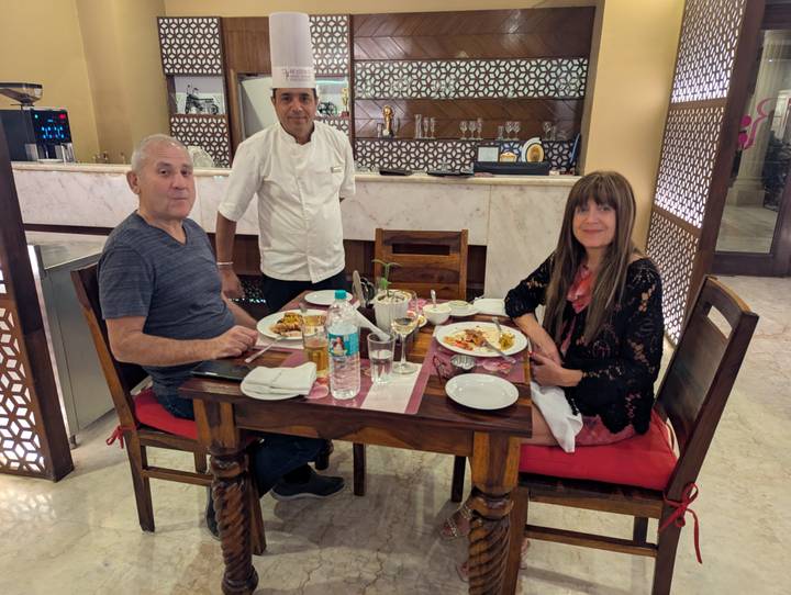 Two people dining in a restaurant with a chef.