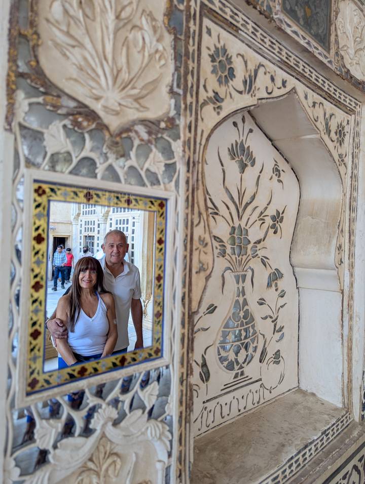 Reflection of a couple in a decorative mirror.
