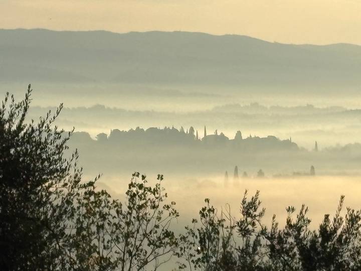 Un paysage brumeux et atmosphérique avec une ville en silhouette.