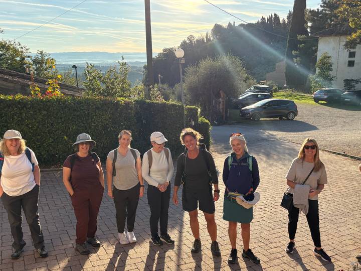 Un groupe de personnes à l'extérieur avec un paysage vallonné en arrière-plan.