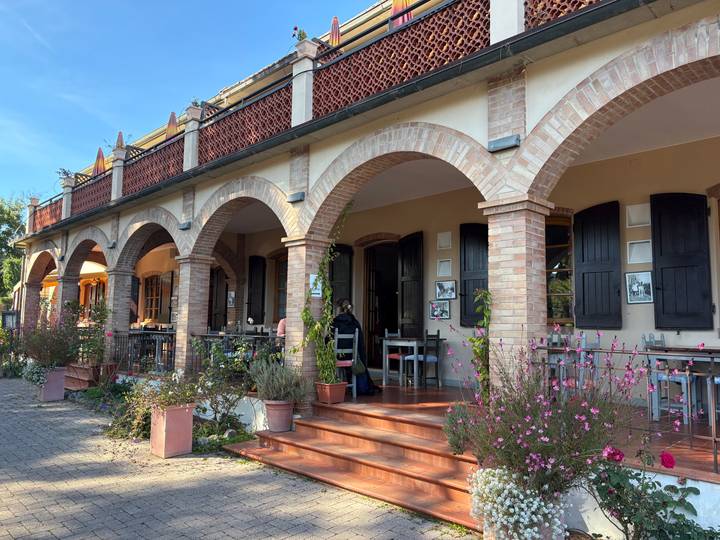 Un bâtiment avec des arches et des sièges extérieurs.