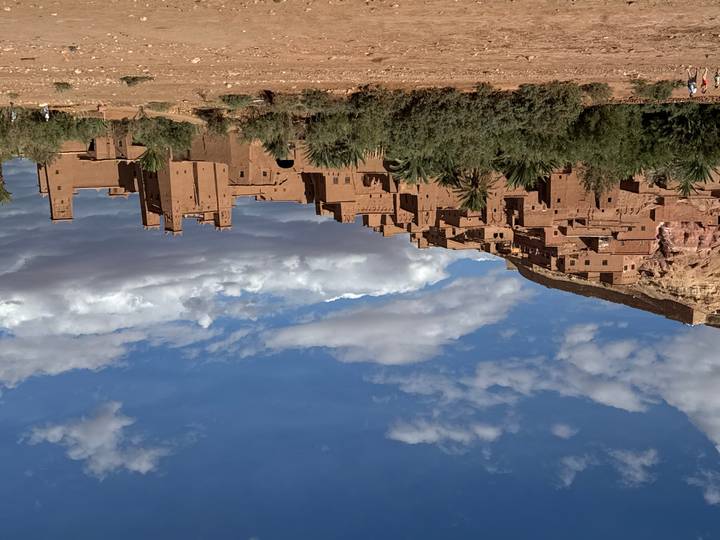 Aït-Ben-Haddou avec son architecture emblématique en briques de terre crue sous un ciel bleu dégagé.