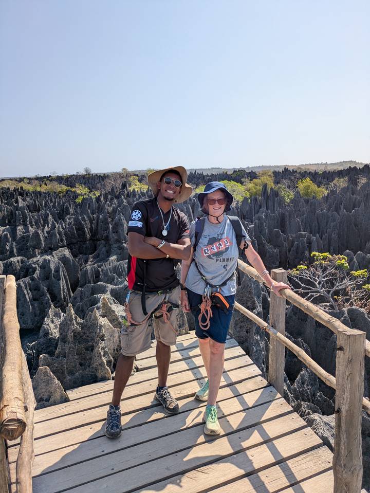 Deux touristes posant sur des formations rocheuses déchiquetées, portant des chapeaux et du matériel.