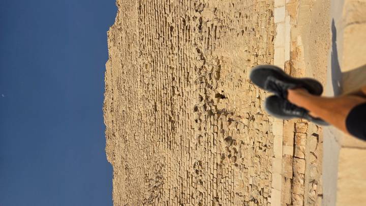 Feet resting with a view of an ancient Egyptian pyramid.