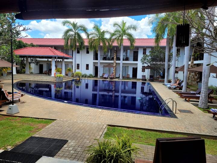 Piscine d'hôtel avec des gens qui se détendent autour.