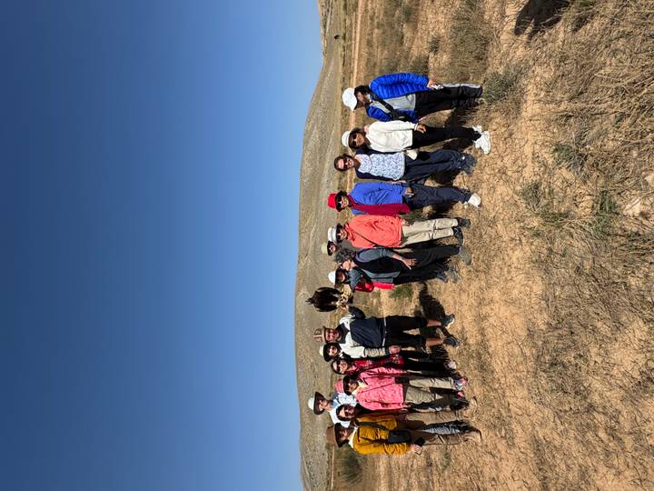 Grupo de personas paradas en un campo con un águila.