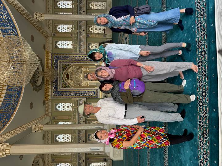 Grupo de personas en un salón lujosamente decorado con arquitectura islámica tradicional.